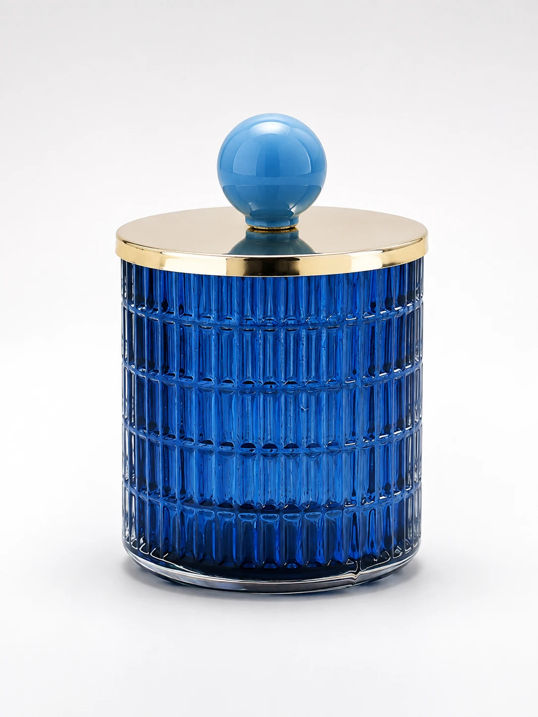 cobalt blue ribbed glass storage jar with a gold-tone metal lid and sky-blue ceramic ball knob