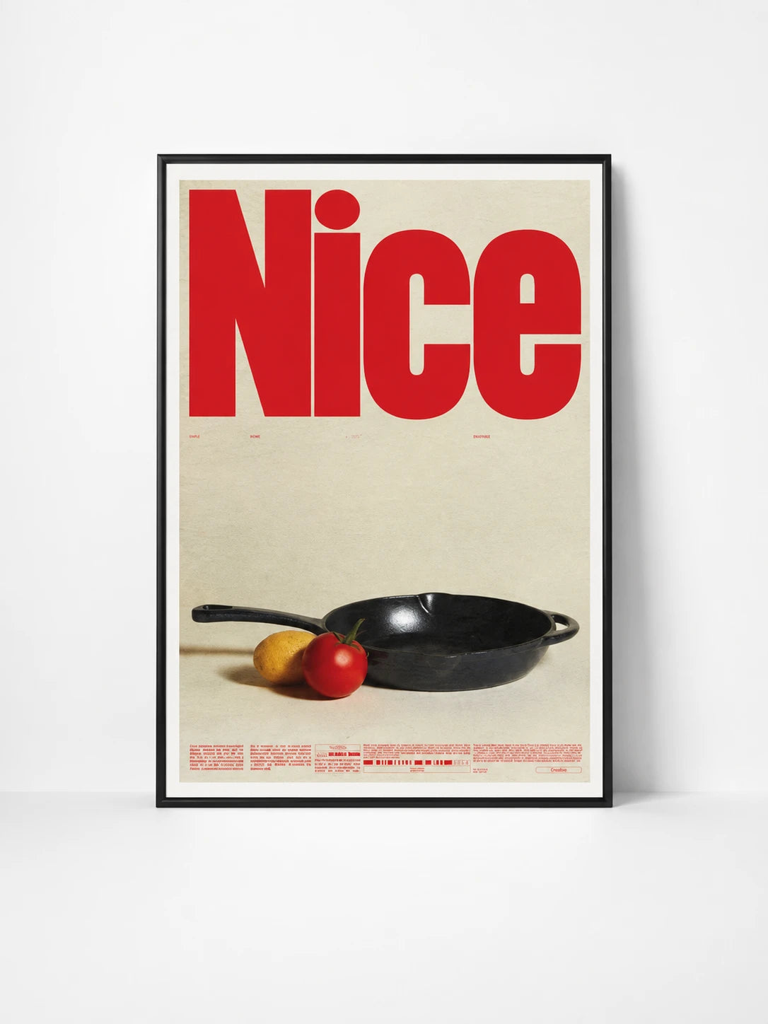 framed typographic poster with the giant red word Nice above a black cast-iron pan, lemon, and tomato