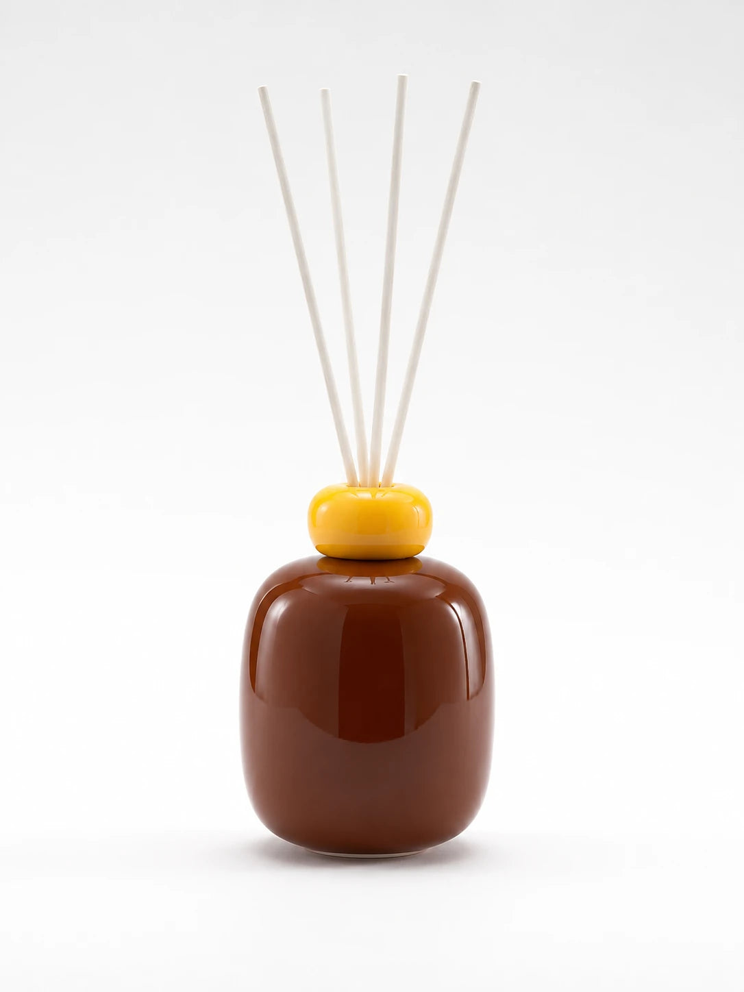 cocoa brown glazed ceramic reed diffuser bottle with a yellow ring cap and four white reeds