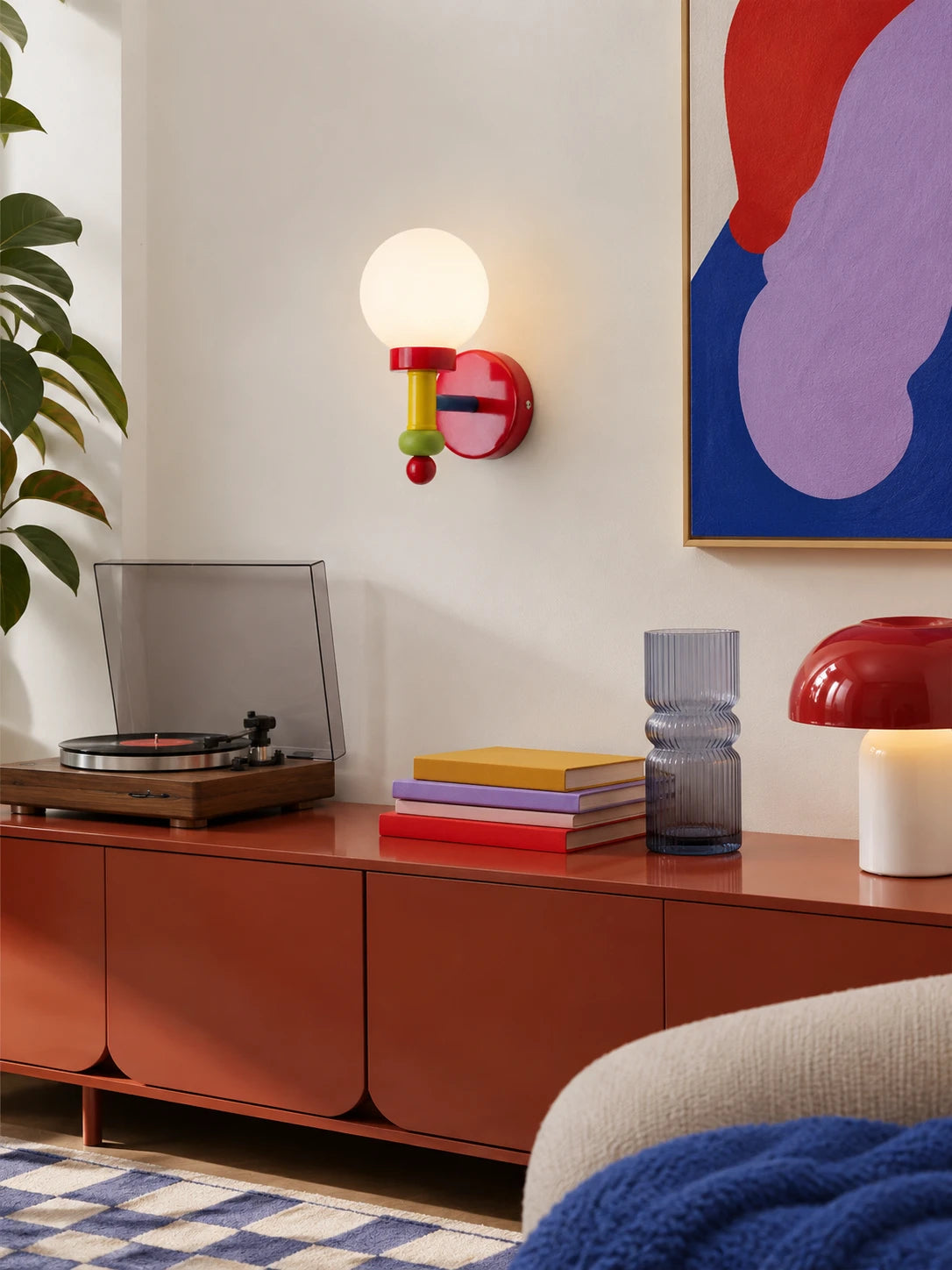Memphis wall lamp glowing above a red sideboard with a record player