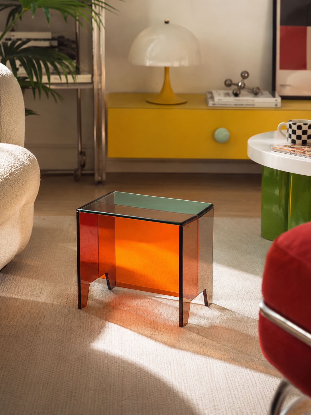 translucent orange acrylic low stool catching sunlight on a cream rug beside a boucle armchair