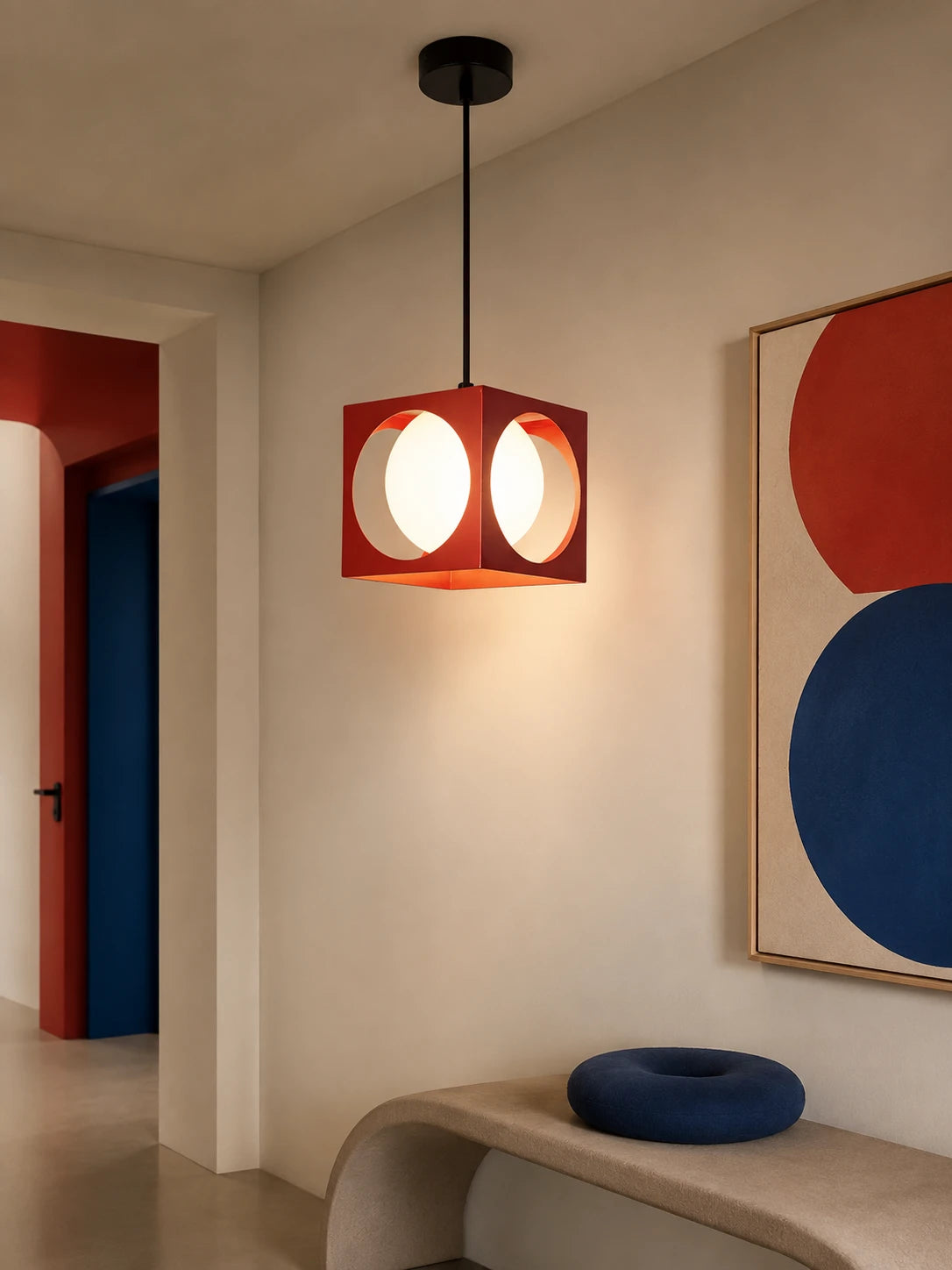 red space age cube pendant glowing warm above a beige bench with a navy cushion in a hallway