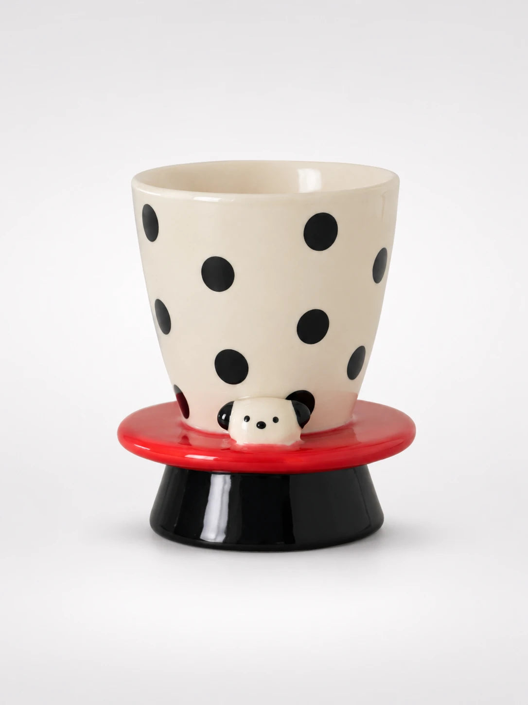 polka dot ceramic goblet with red brim, black pedestal base and tiny puppy face peeking out