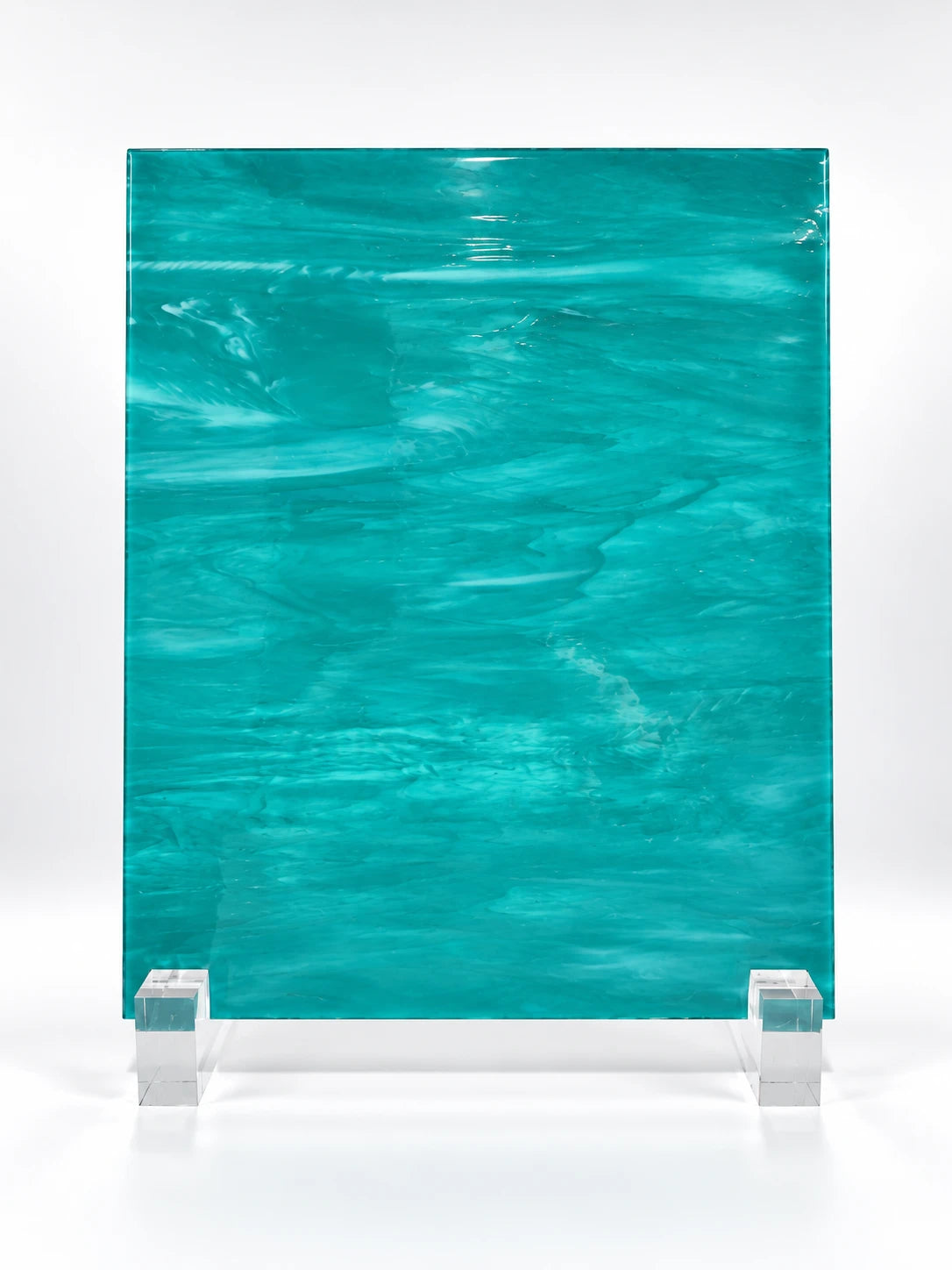teal wisp-textured art glass sheet on clear stands, studio view