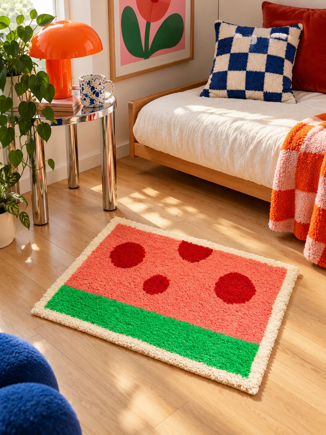 watermelon mat on wood floor in front of a cream daybed with checkered pillows