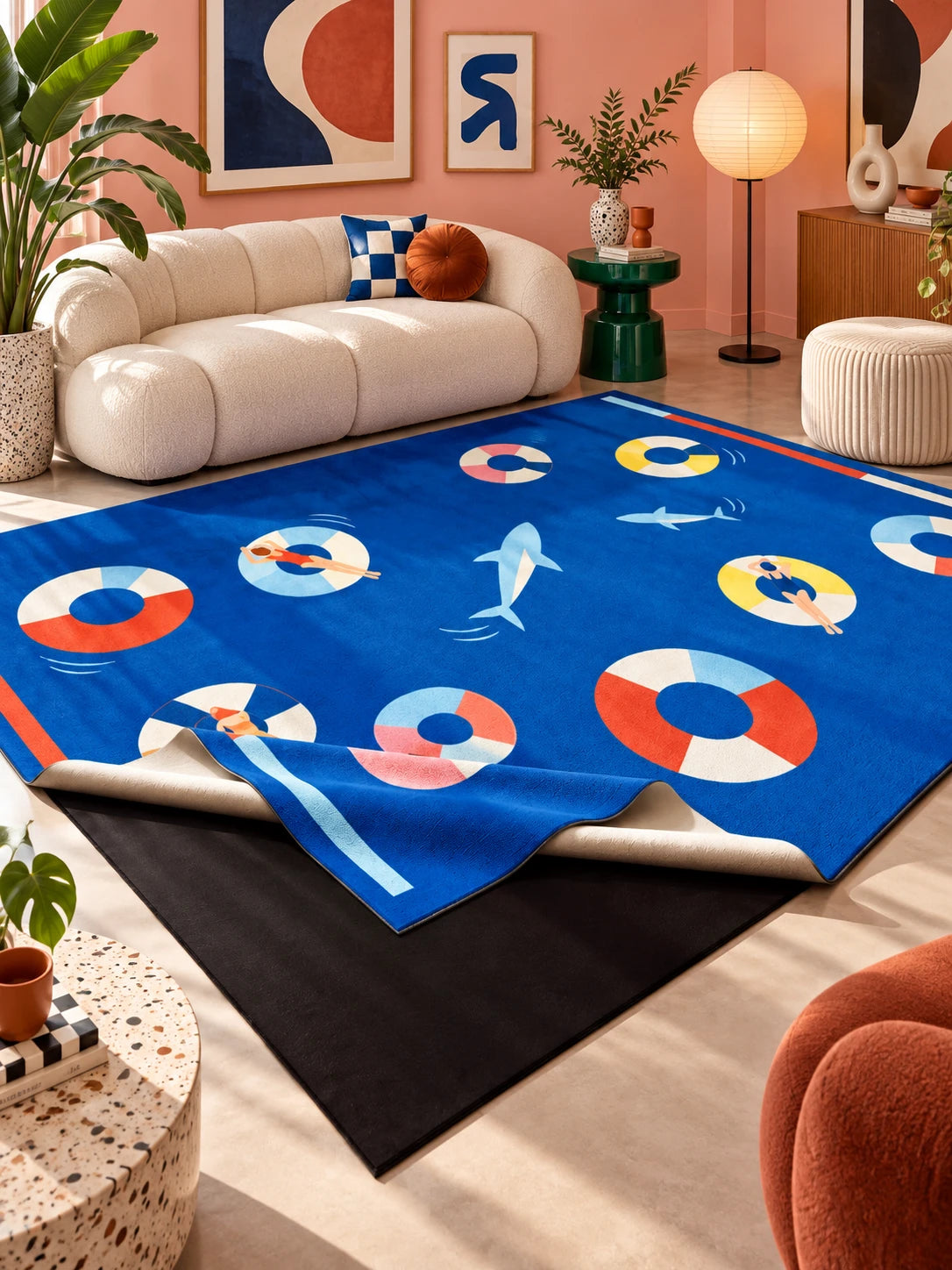 Cobalt swim ring rug in a pink living room with a cream sofa, paper lantern floor lamp and terrazzo side table