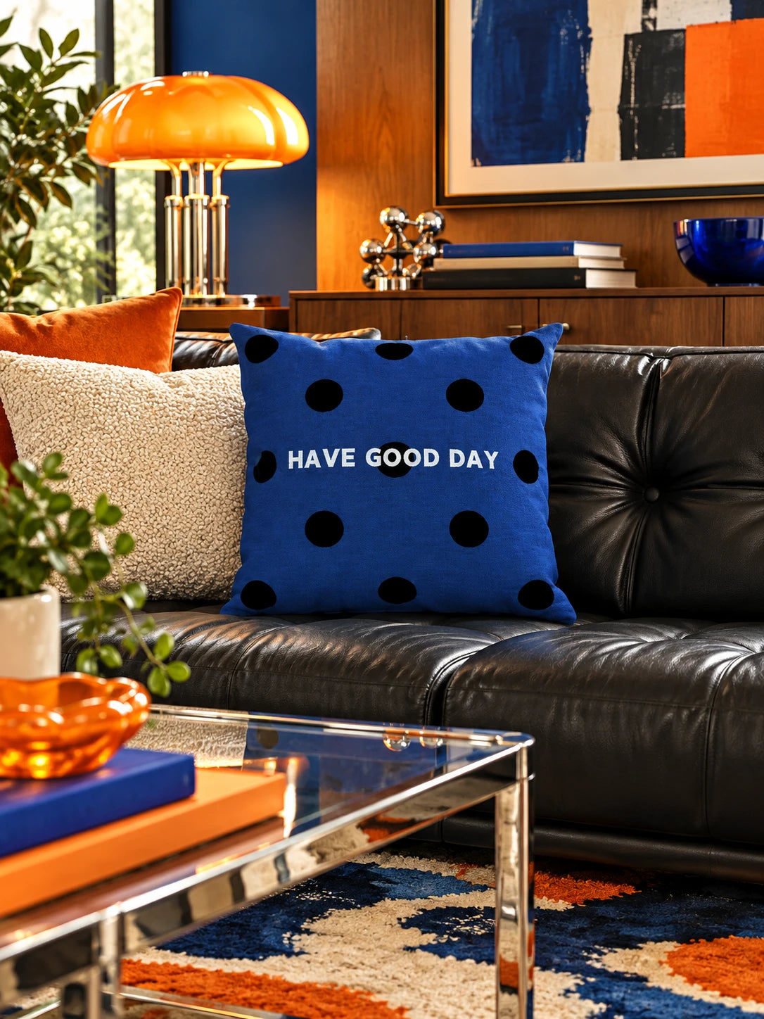 navy HAVE GOOD DAY pillow on a black leather sofa in a mid-century living room