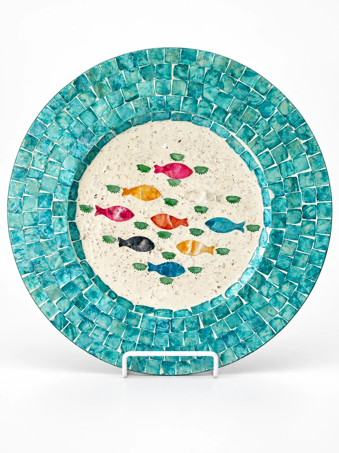 Turquoise seashell mosaic fish tray on a white display stand, studio shot