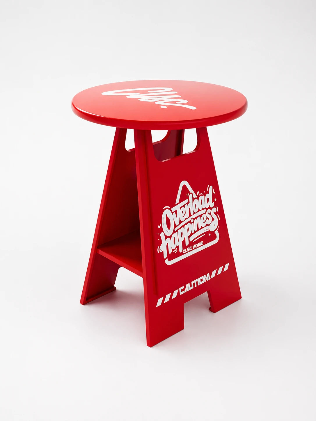 glossy red A-frame side table shaped like a wet-floor caution sign with a round top, white script graphics, and a low shelf