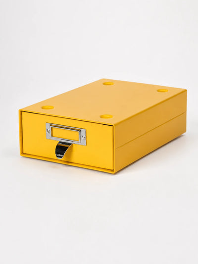 yellow steel desktop storage drawer with chrome label frame and curved pull tab