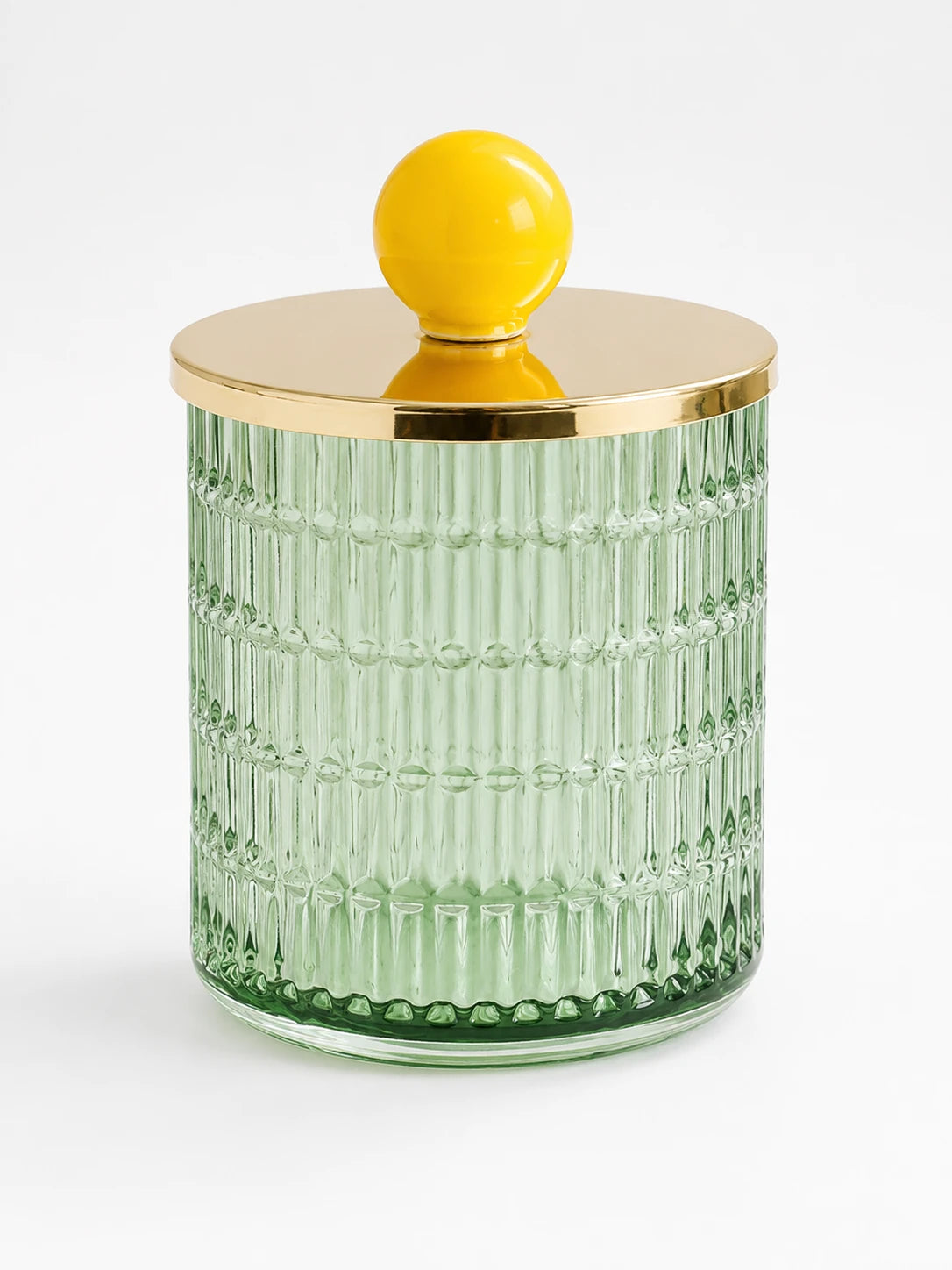 mint green ribbed glass storage jar with a gold-tone metal lid and glossy yellow ceramic ball knob