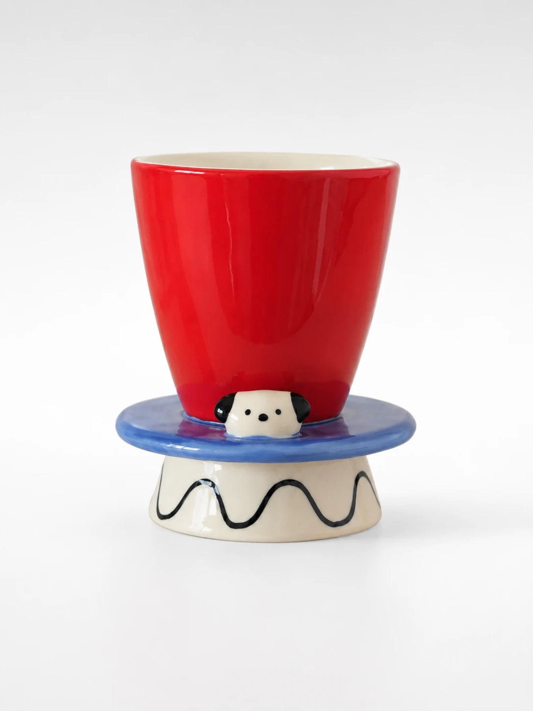 red ceramic goblet with blue hat-brim disc, sculpted puppy face and squiggle-painted base