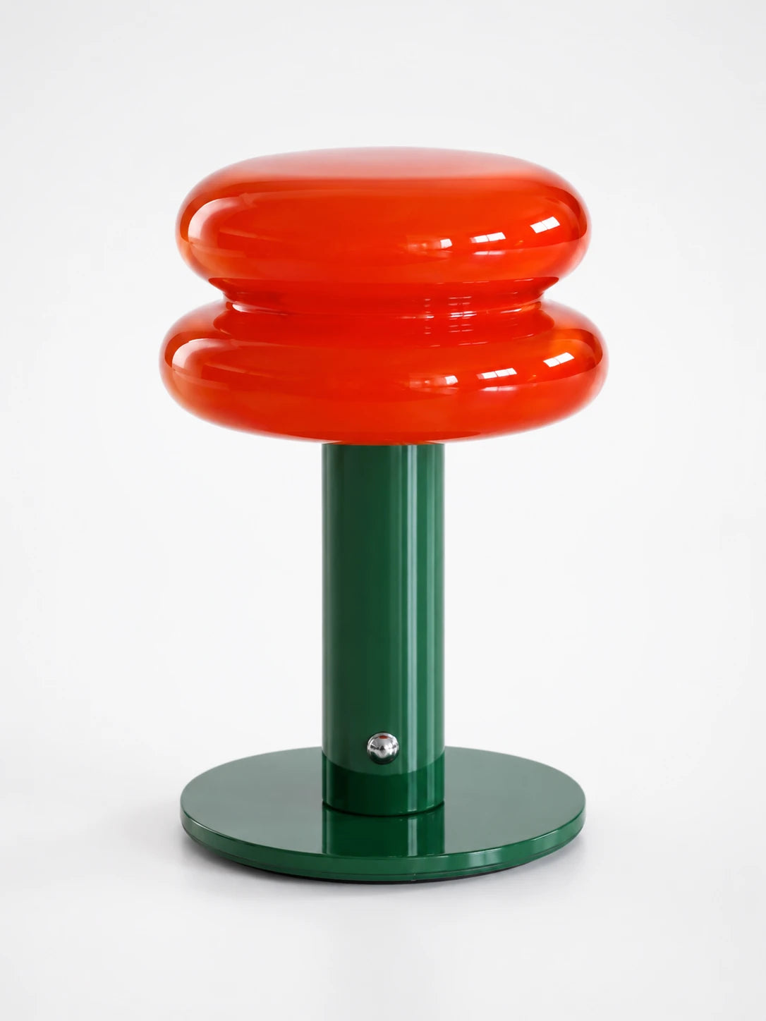 glossy red double-bulge glass lamp shade on a dark green stem and disc base