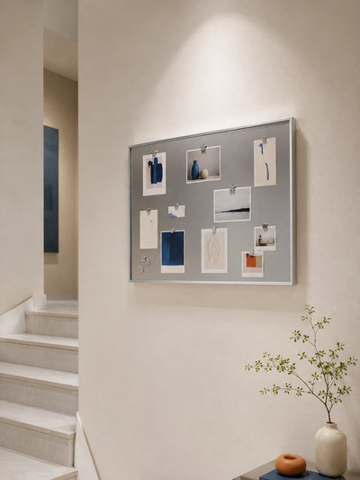 silver magnetic board on a stairway wall holding art cards with small star magnets