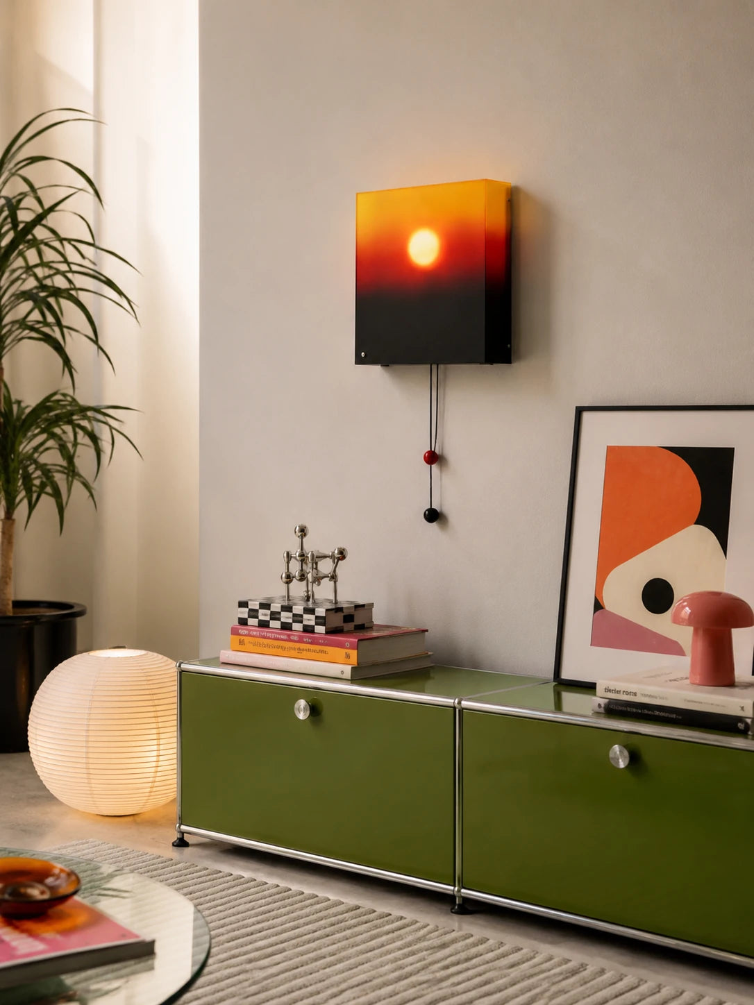 sunset lightbox wall lamp lit above a green modular sideboard with a paper globe floor lamp