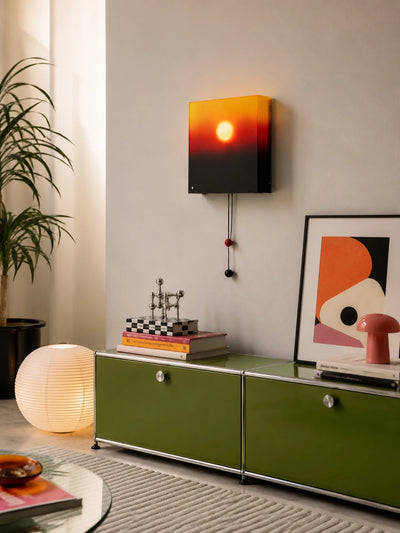 sunset lightbox wall lamp lit above a green modular sideboard with a paper globe floor lamp