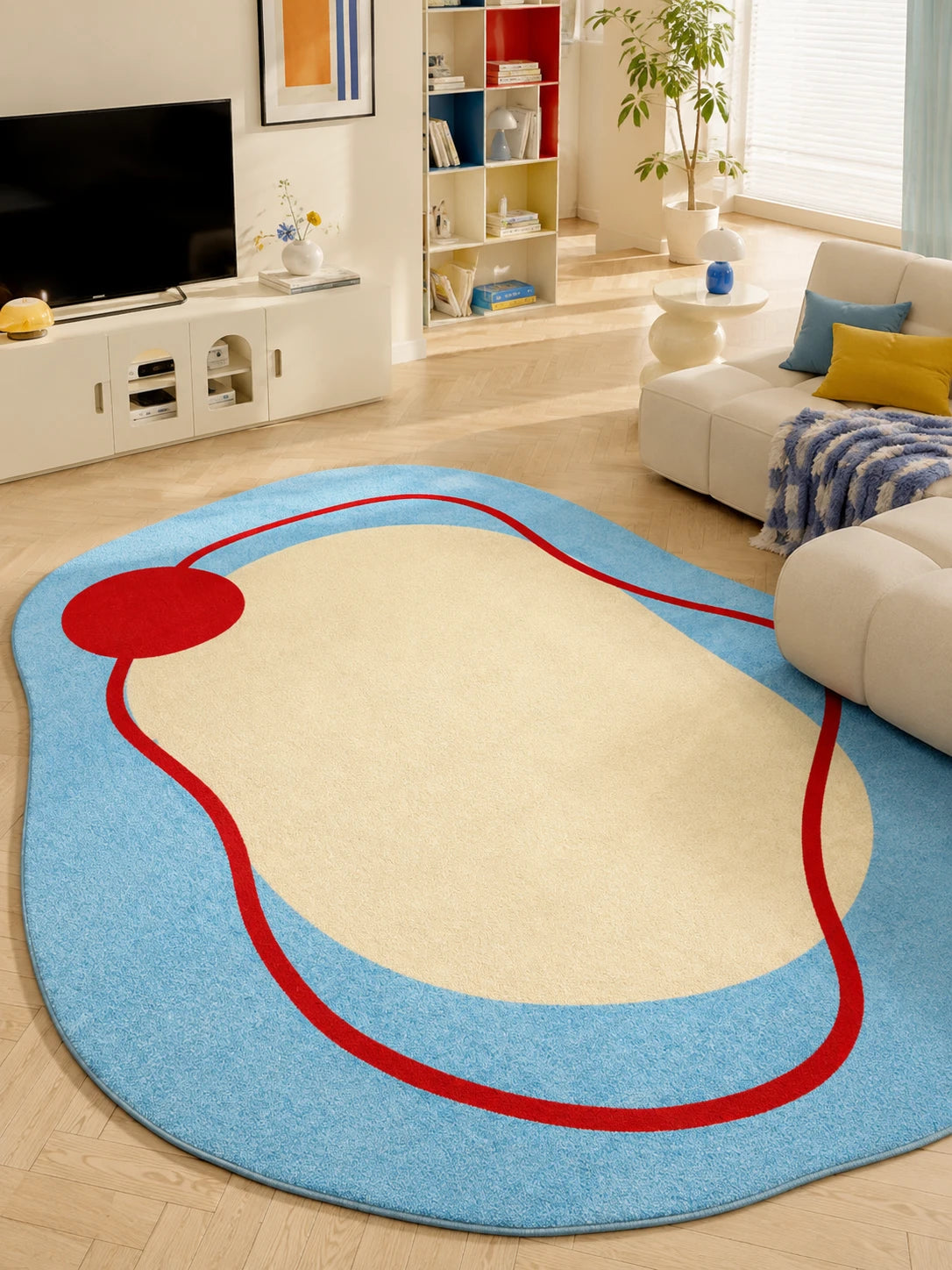irregular blue rug with red squiggle in a living room beside a white sofa and TV console
