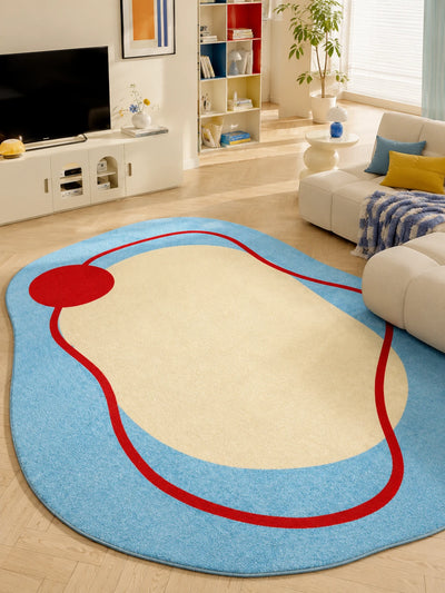 irregular blue rug with red squiggle in a living room beside a white sofa and TV console