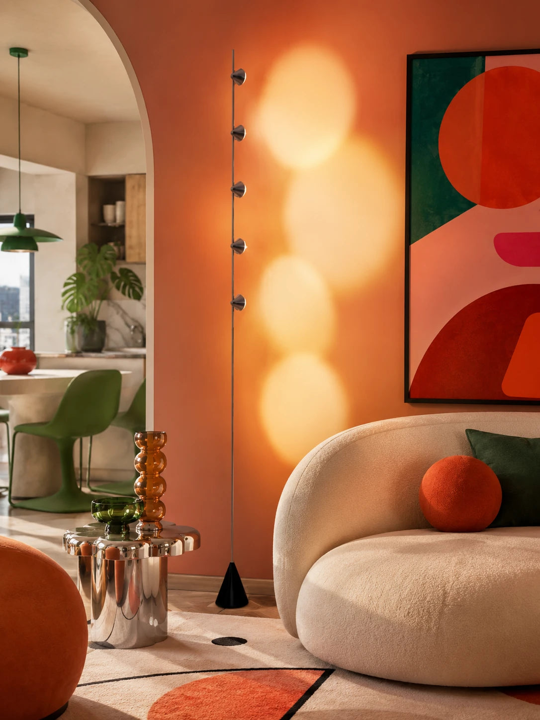 five-cone floor lamp projecting glowing sunset pools on a terracotta wall behind a cream boucle sofa