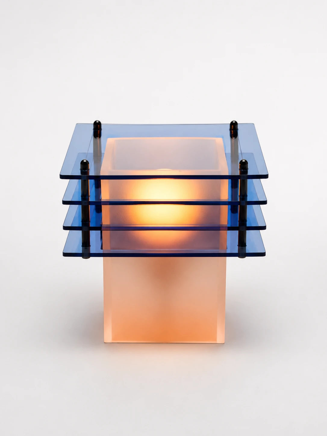 ocean blue acrylic table lamp with four tinted square tiers glowing warm around a frosted base