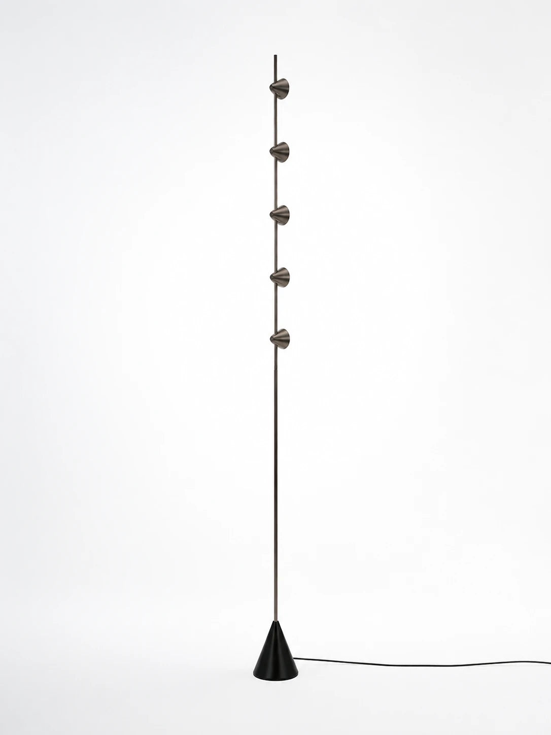 slim floor lamp with five small steel cones staggered on a thin rod above a black cone base