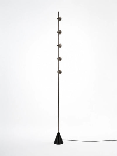 slim floor lamp with five small steel cones staggered on a thin rod above a black cone base