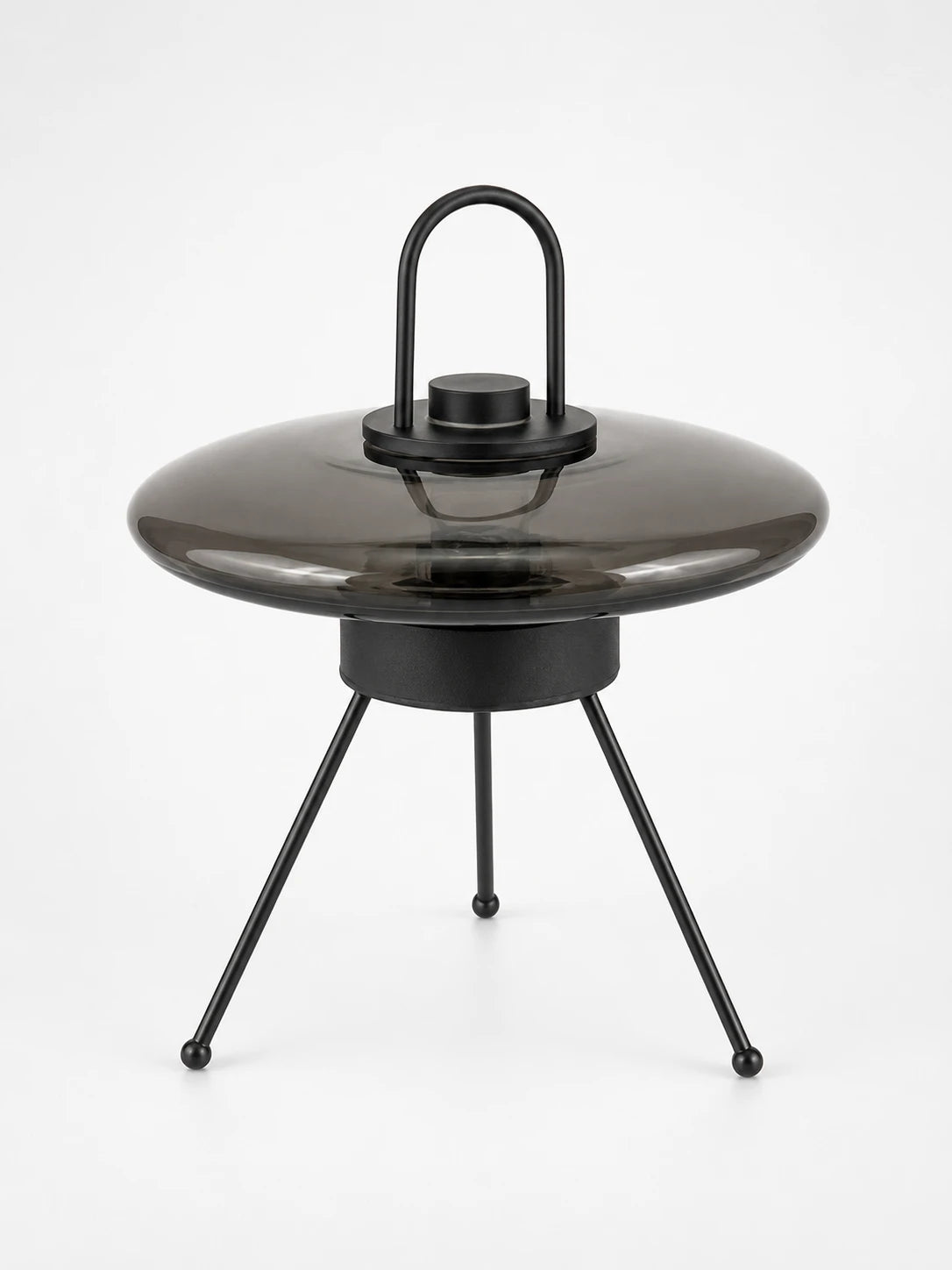 Smoked glass UFO saucer lamp with a black loop handle on a tripod base with ball feet, unlit studio view