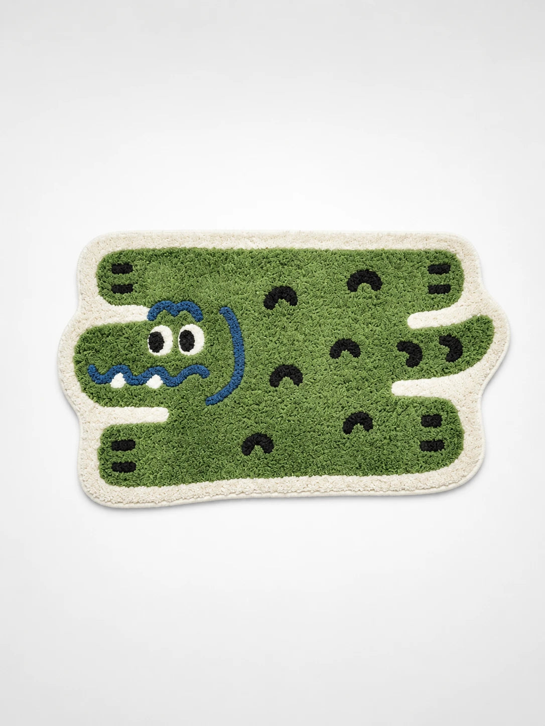 green tufted alligator bath mat with googly eyes, wavy blue grin and cream shag border
