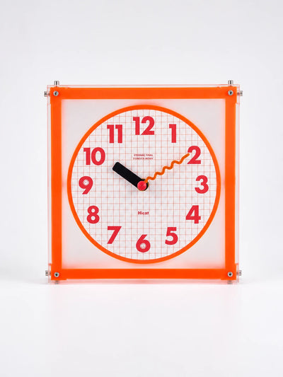 square corner clock with fluorescent orange acrylic frame, graph paper grid dial, and red numerals