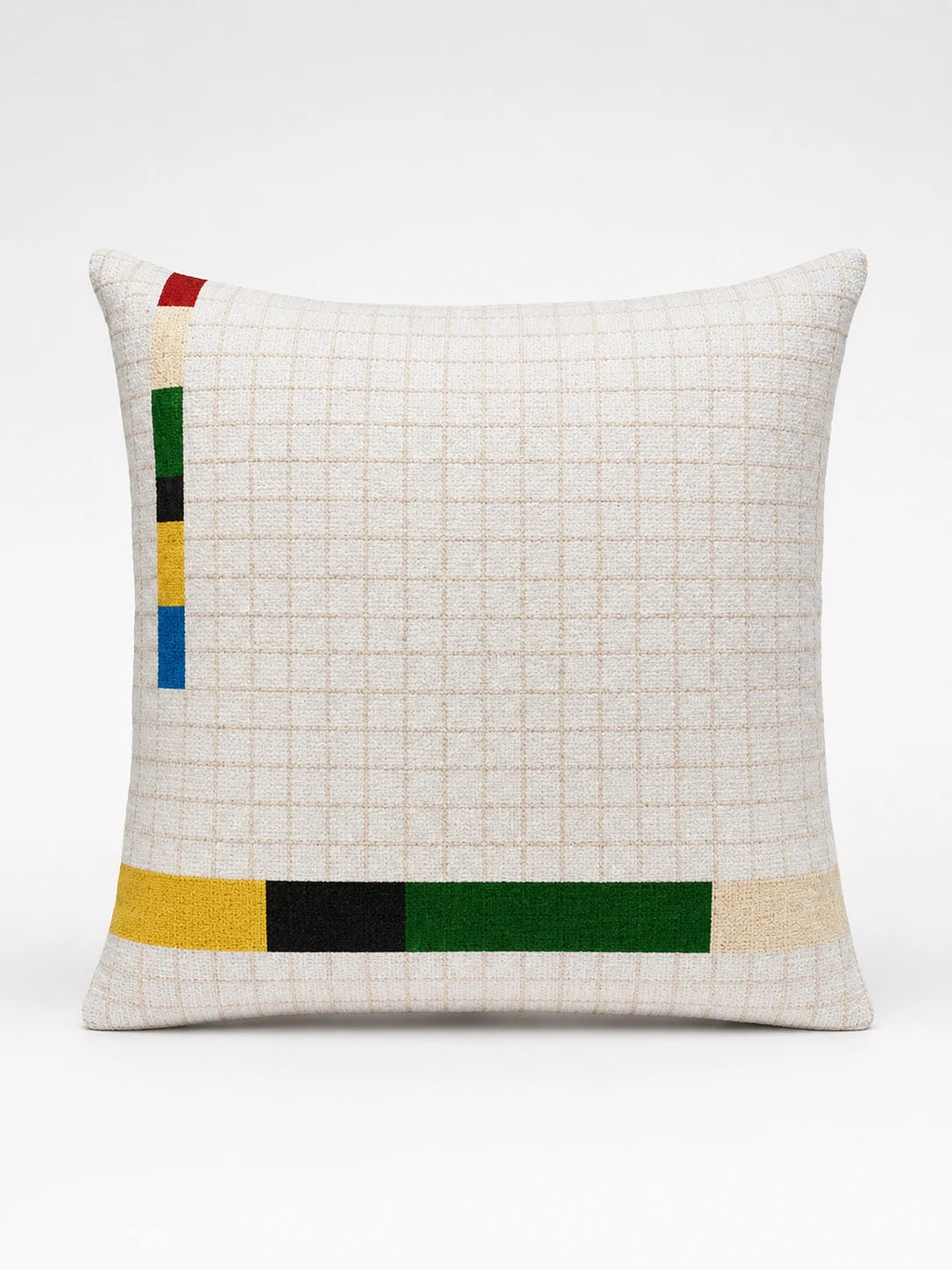 cream graph-grid cushion with a vertical multicolour bar at the left edge and a yellow, black and green bar along the bottom