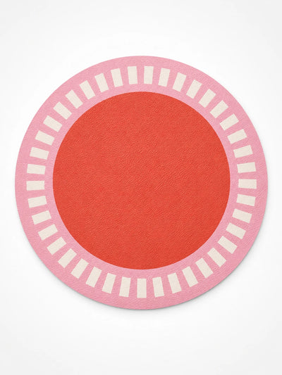 pink round placemat with a cream tick ring around a tomato-red centre, flat lay