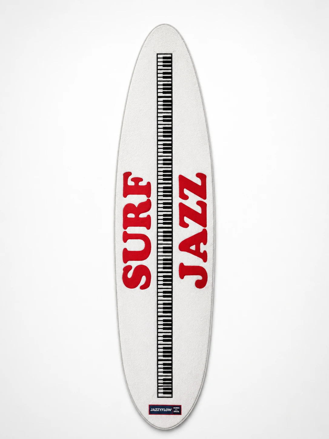 white surfboard-shaped plush runner rug with red lettering and a black piano-key stripe down the center