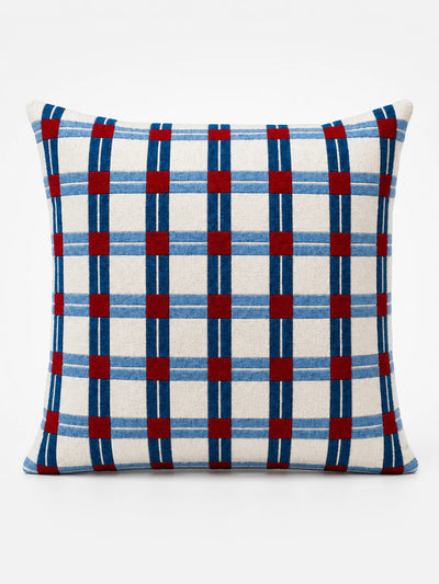 cream square cushion with a navy and light-blue windowpane check and red squares at the intersections