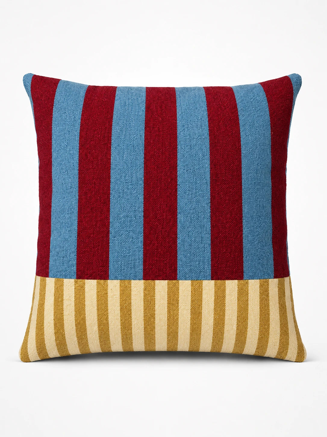 throw pillow with wide red and sky-blue vertical stripes above a band of thin mustard and cream pinstripes