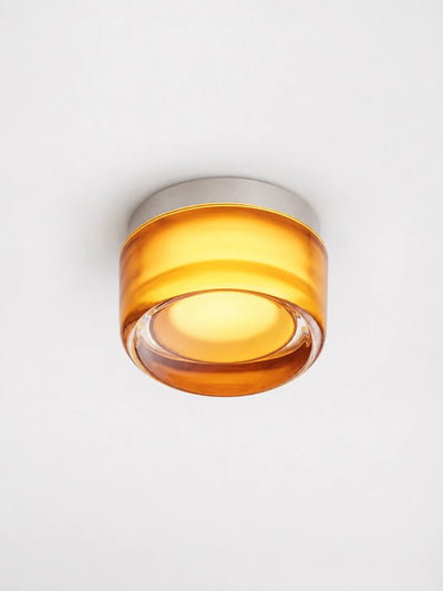 amber acrylic disk wall lamp glowing in a hallway