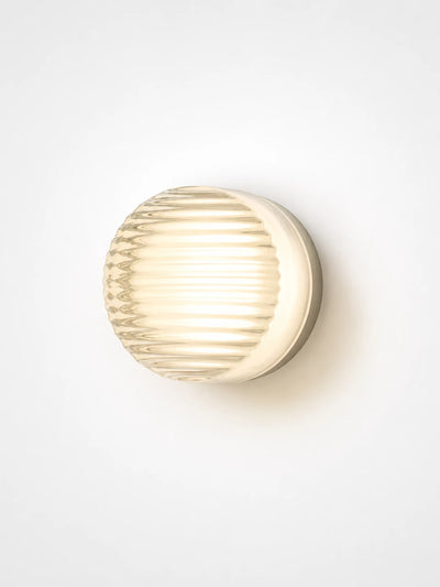 amber acrylic disk wall lamp glowing in a hallway