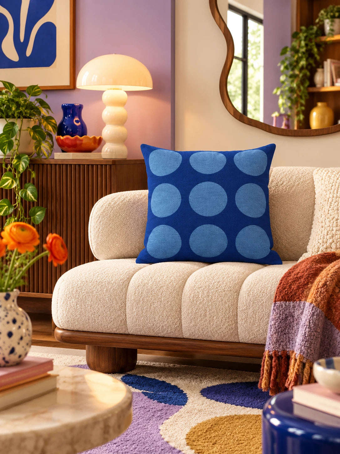 blue dot-grid pillow on a beige sofa beside a terracotta cushion