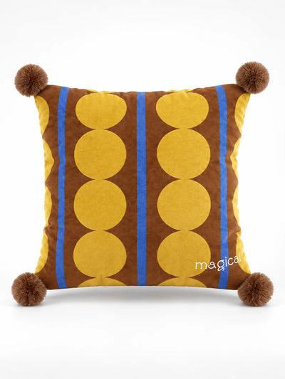 Brown throw pillow with columns of yellow polka dots, cobalt stripes and brown pompom corners