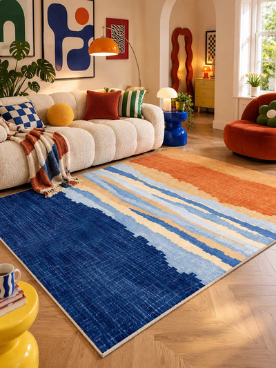 Blue-orange gradient rug in daylight with an orange arc floor lamp and gallery wall