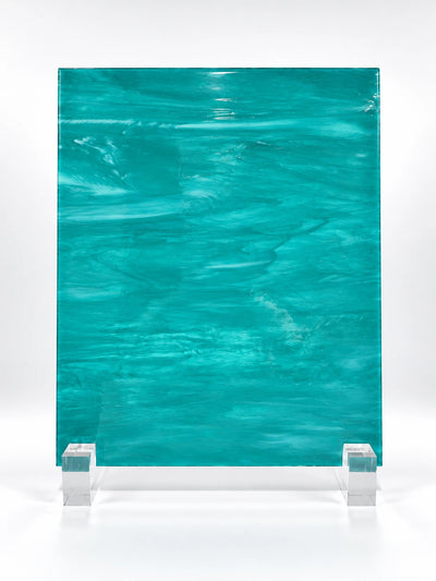 teal wisp-textured art glass sheet on clear stands, studio view