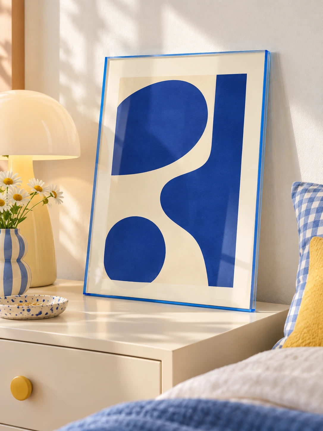 blue tinted acrylic frame with blue shapes print on a cream nightstand