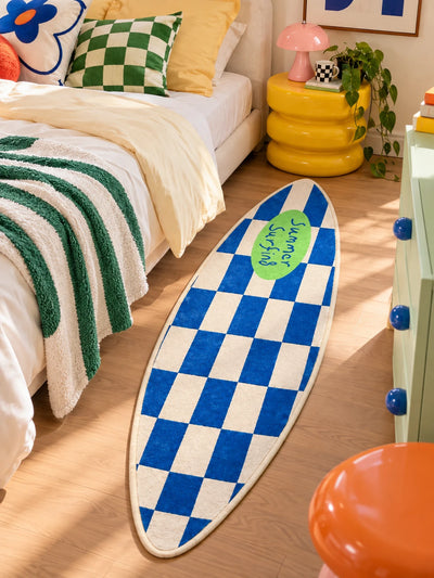 Checkerboard surfboard rug at the foot of a bed with green checkered pillow and yellow stool