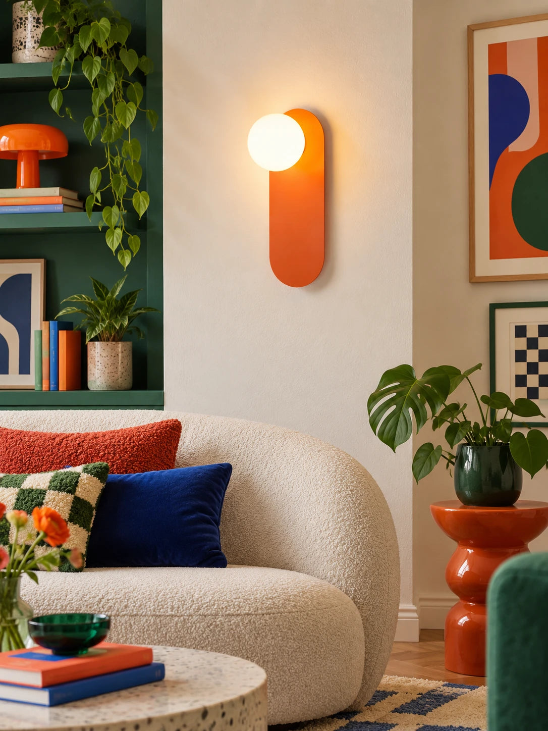 Wall lamp glowing on a green wall beside open shelving