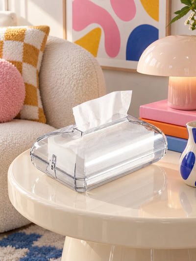 Clear acrylic tissue box on a cream side table beside a boucle sofa