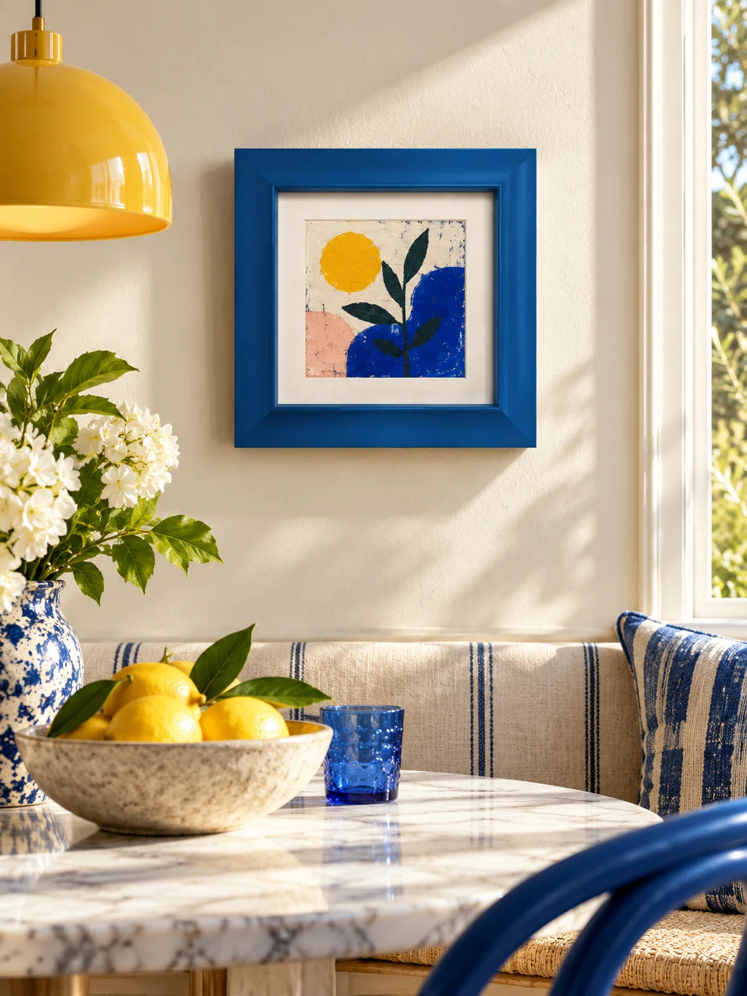 
blue bevelled wood frame with sun and plant print in a breakfast nook