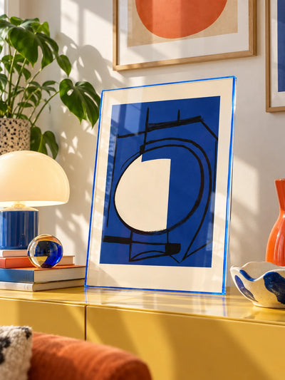 blue tinted acrylic poster frame with abstract print on a yellow credenza