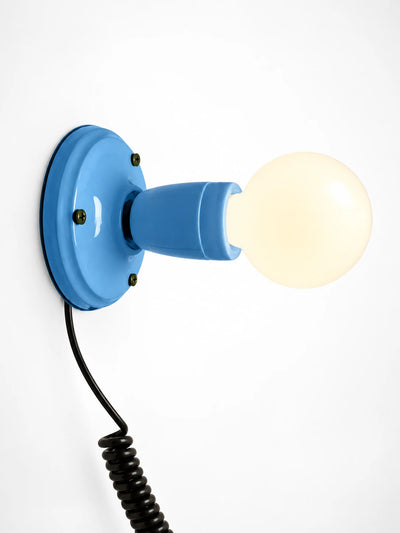 sky blue ceramic wall light with an opal globe bulb and coiled black cord, studio shot on white