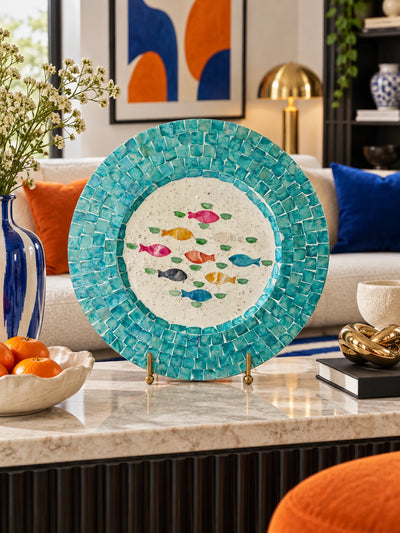 Mosaic fish display plate on a marble coffee table with oranges and a gold knot