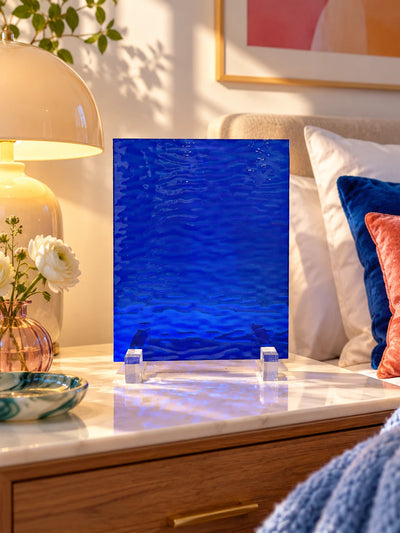 cobalt water-ripple glass sheet on a marble nightstand beside white flowers