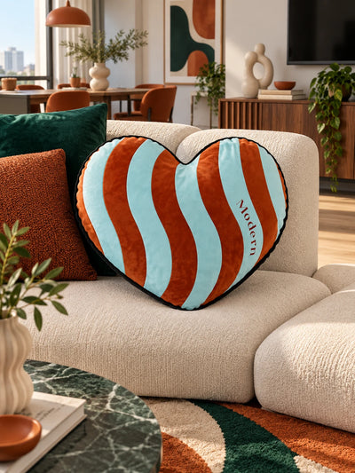 Aqua and rust striped heart pillow on a white boucle sectional sofa